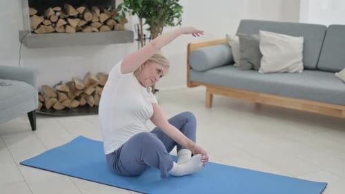 Senior Woman Stretching Her Legs On Exercise Mat