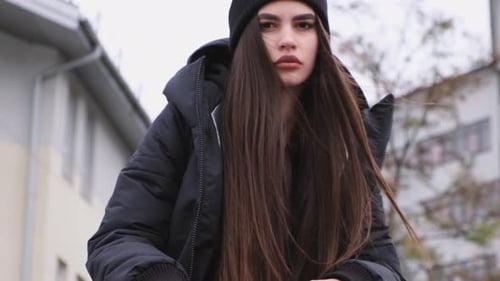 Young Woman in Black Winter Coat Posing