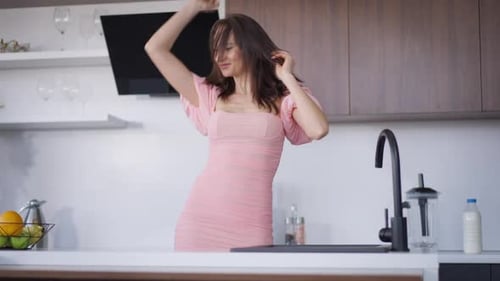 Young Woman Dancing in Modern Kitchen