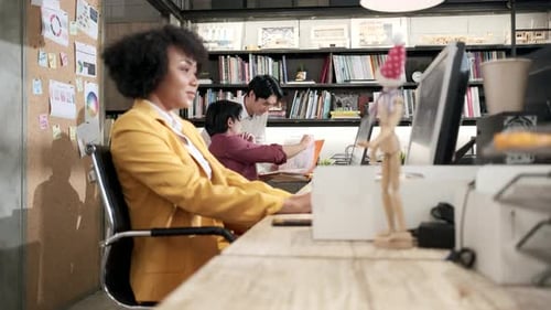 Asian male colleagues work at the open office with multiracial coworkers.