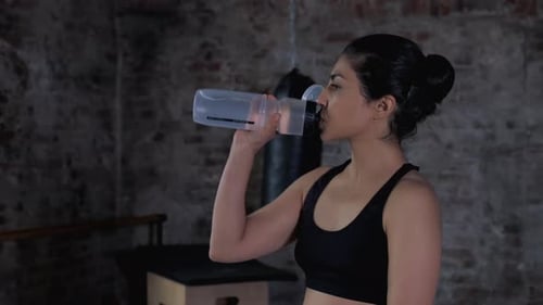 Fit Woman Drinking Water After Workout