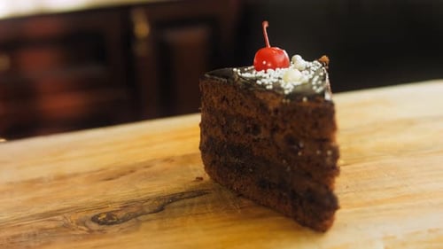 Chocolate Cake Slice with Cherry Topping on Board