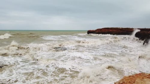 Big Waves Break on the Rocky Shore, White Foam on the Water