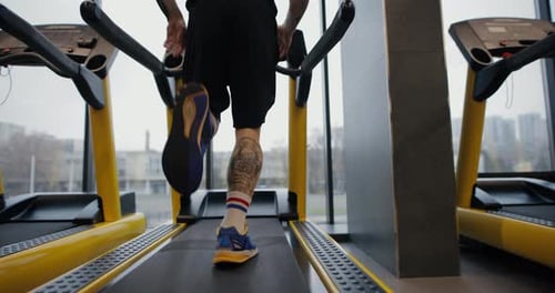 Legs of Man Running on a Treadmill in Gym Slow Motion