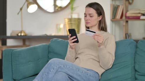 Online Payment Loss on Smartphone By Young Woman on Sofa