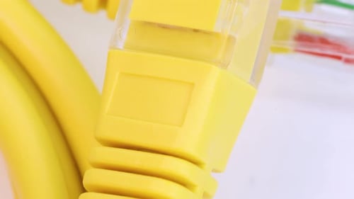 Close up view of yellow ethernet cable rotating on white surface, close up view.