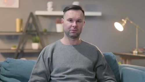 Adult Man Sitting on Blue Couch Indoors