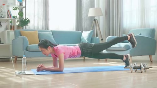 Woman Doing Plank Exercise at Home Watching Laptop