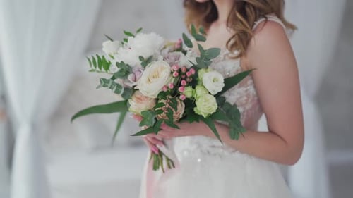 Bride Holding Bouquet of Flowers in Bridal Gown