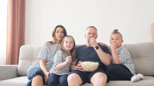 Family Watching Television and Eating Popcorn Together
