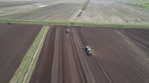 Traktor auf landwirtschaftlichen Flächen wird mit Düngemitteln kultiviert