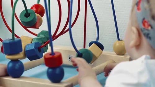 Infant Plays with Colorful Geometric Wooden Toy