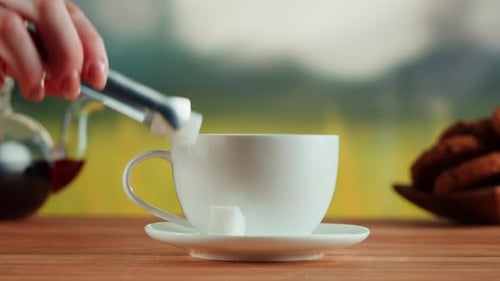 Putting Sugar Into White Cup Closeup