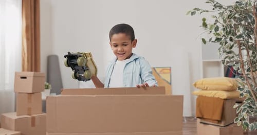 A Cute Little Boy Unpacks His Toy Box After Moving to a New House Pulls Out a Car Enjoys It Plays