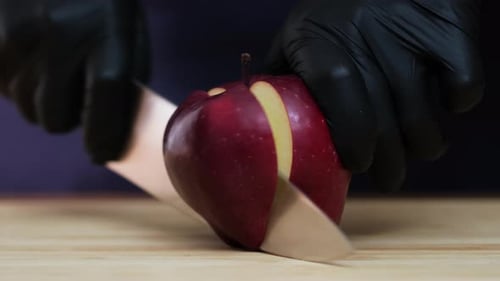 Schneidet einen Apfel mit einem Messer in zwei Hälften