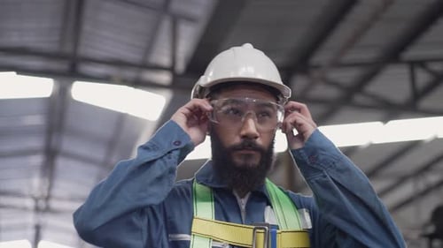 Construction Worker Puts on Protective Safety Goggles