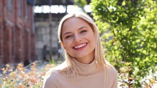 Woman Smiling in Front of Building and Plants