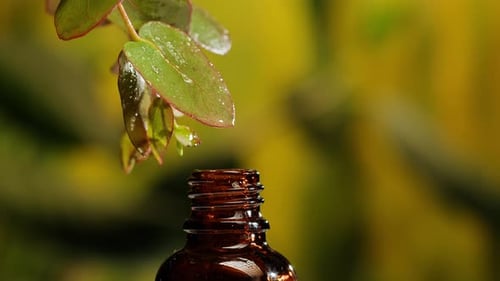 Liquid Drops Falling into Glass Medicine Bottle