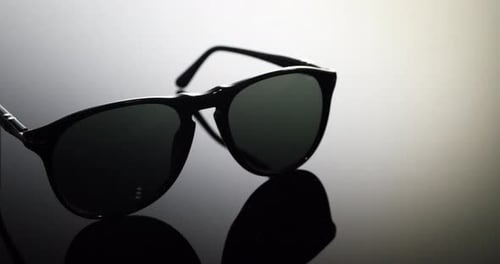 A pair of expensive luxury aviator sunglasses with polarized lenses on a black and white background