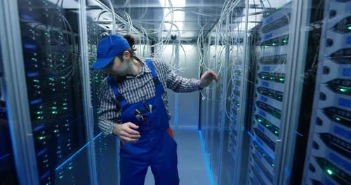 Technician Passing Through Cables at a Data Center