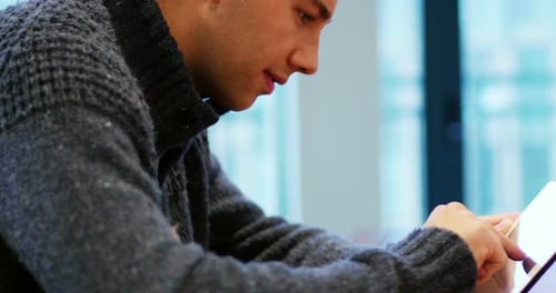 Young Man Using a Tablet Device Indoors