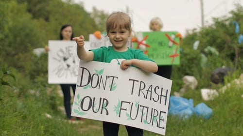 Child Leads Environmental Protest on Grassy Path