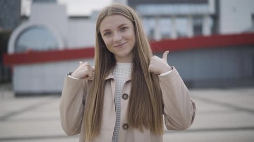 Smiling Woman Gives Thumbs Up in Urban Setting