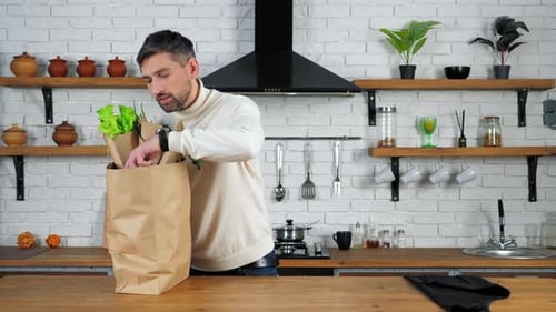Man Carrying Groceries into Kitchen with Gray Hair