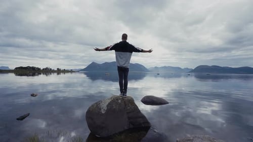 Man on rock in peaceful lake