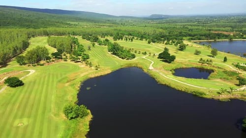 4K Aerial view of golf course with green lawn fairway and trees in summer sunny day