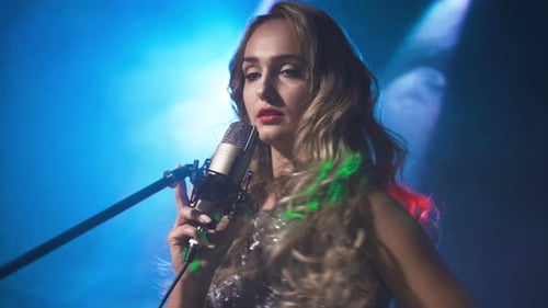 Female Singer Performs on Stage with Microphone