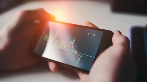 A Man Is Checking Stock Market on a Smartphone Screen