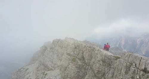 Aerial drone view of a man and woman couple hiking in the mountains