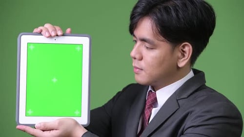 Young Adult Displaying Tablet with Green Screen