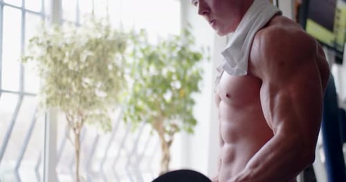 Shirtless Man Doing Bicep Curls with Dumbbell