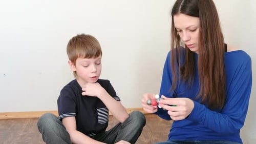 Mom with Son Building Molecule Models of Colored Plastic Construction Set.