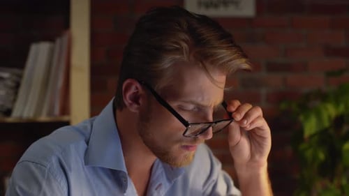 Busy Caucasian Male with Glasses Light Beard and Blue Shirt Questionably Looking