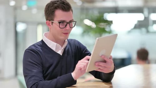 Excited Young Adult Celebrating Success on Tablet