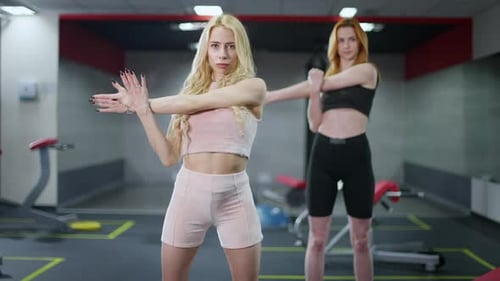 Women Stretching Arms in Gym