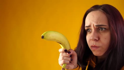 Young Woman Holding Banana as a Gun
