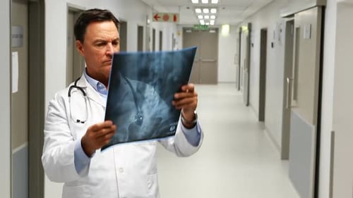 Doctor Examines X-Ray in Bright Hospital Corridor