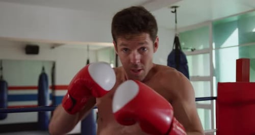 Caucasian man boxing in boxing gym
