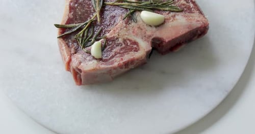 Steak frais T-Bone ou Porterhouse vieilli à sec sur planche à découper en marbre. Mariner dans de l'huile d'olive
