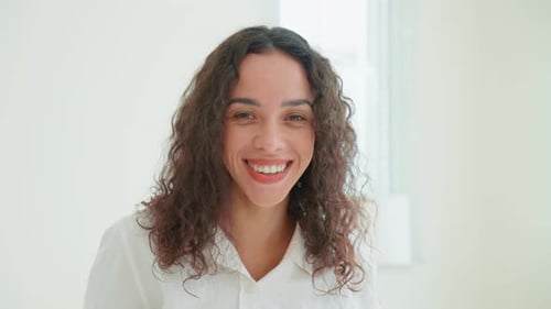 Smiling Woman with Curly Hair Posing Indoors