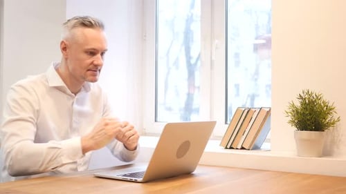 Man Works on Laptop and Celebrates Success