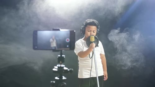 Young Person Sings into Microphone While Being Recorded