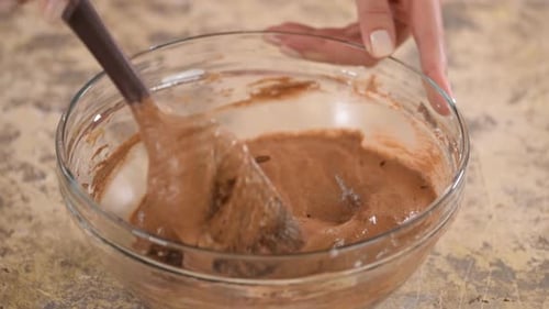 Mixing Chocolate Batter with Spatula in Clear Bowl