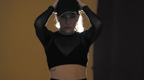Blonde Frau tanzt auf dem Hintergrund heller Beleuchtung