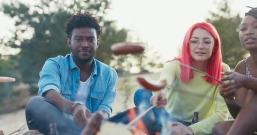 Students Meet in the Evening to Roast Sausages Together Over a Campfire By the Lake Spend Time