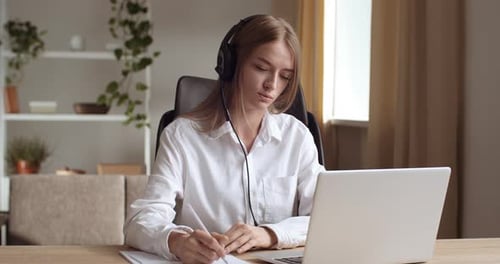 Young Woman Telecommuting with Laptop and Headphones